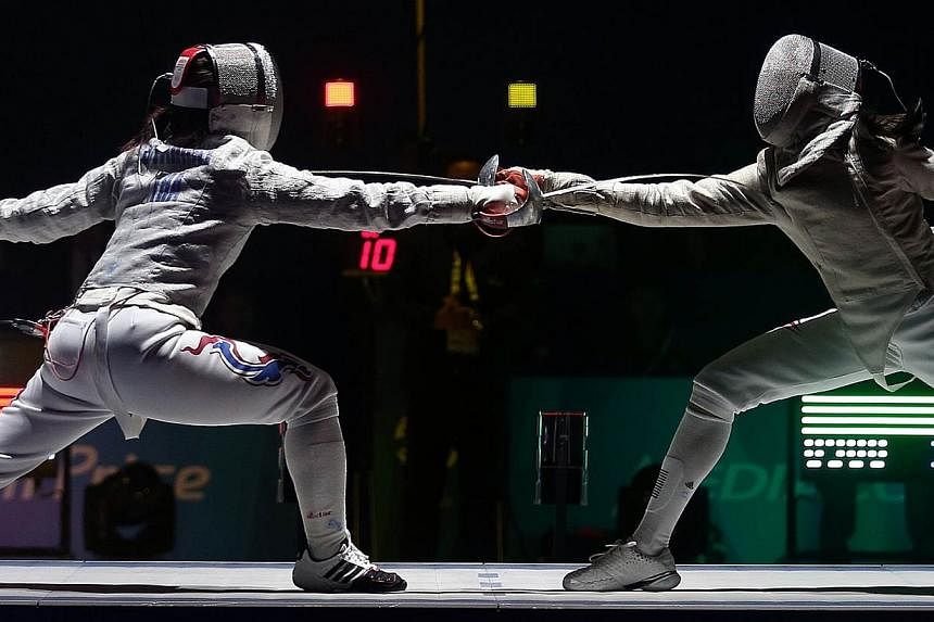 Thailand's Starrat Sirawalai (left) beats Singapore's Ywen Lau 15-13 in the SEA Games fencing women's individual sabre semifinals held at the OCBC Arena Hall 2 on June 4, 2015.&nbsp;The Singapore fencers ended their individual campaigns after winning