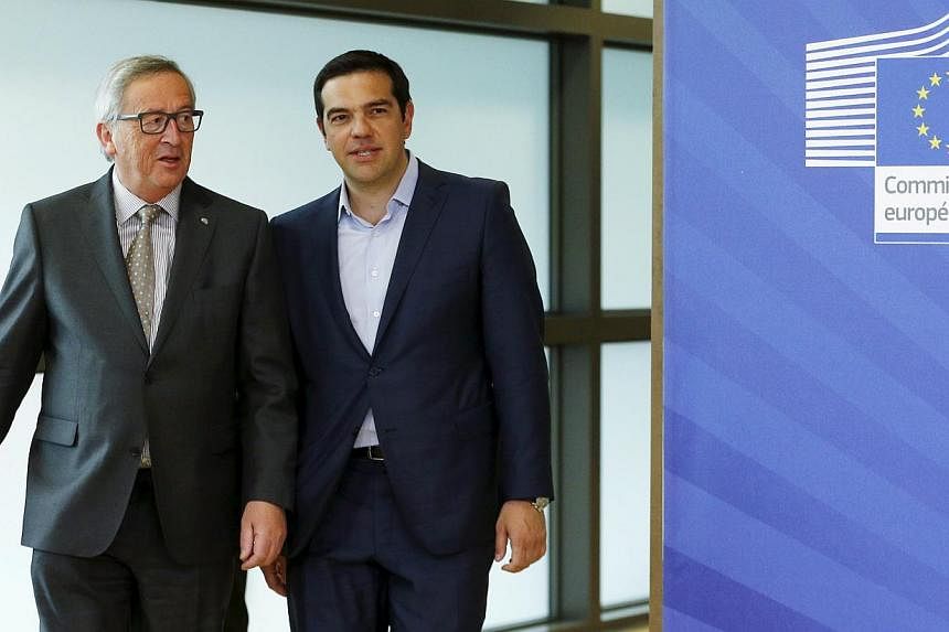 Greece's Prime Minister Alexis Tsipras (right) walking with European Commission President Jean-Claude Juncker (left) ahead of a meeting at the EU Commission headquarters in Brussels, Belgium, on June 3, 2015. -- PHOTO: REUTERS