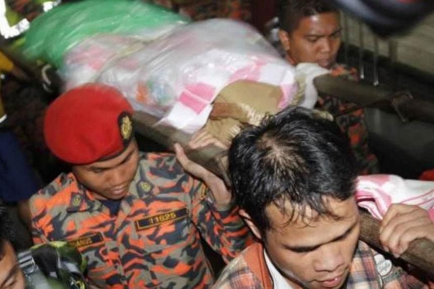 Rescue personnel bringing down a body to the foothill base camp at Timpohon gate in Kinabalu Park, Kundasang on Friday. -- PHOTO: THE STAR/ASIA NEWS NETWORK