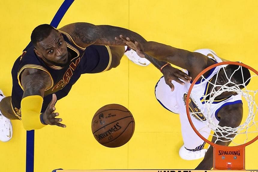 Cleveland Cavaliers player LeBron James (left) goes to the basket against Golden State Warriors player Draymond Green (right) in the first half of Game One of the NBA Finals at the Oracle Arena in Oakland, California on Thursday (June 4). -- PHOTO: E
