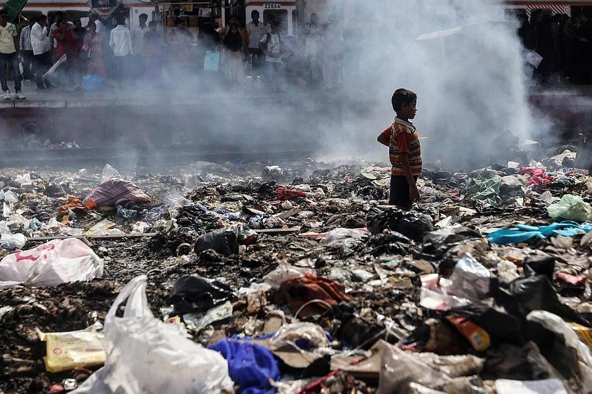 An Indian child looking for reusable materials in a pile of rubbish at a train station in Mumbai, India, on June 4, 2015. World Environment Day is celebrated on June 5 every year to raise global awareness for the need to take positive environmental a