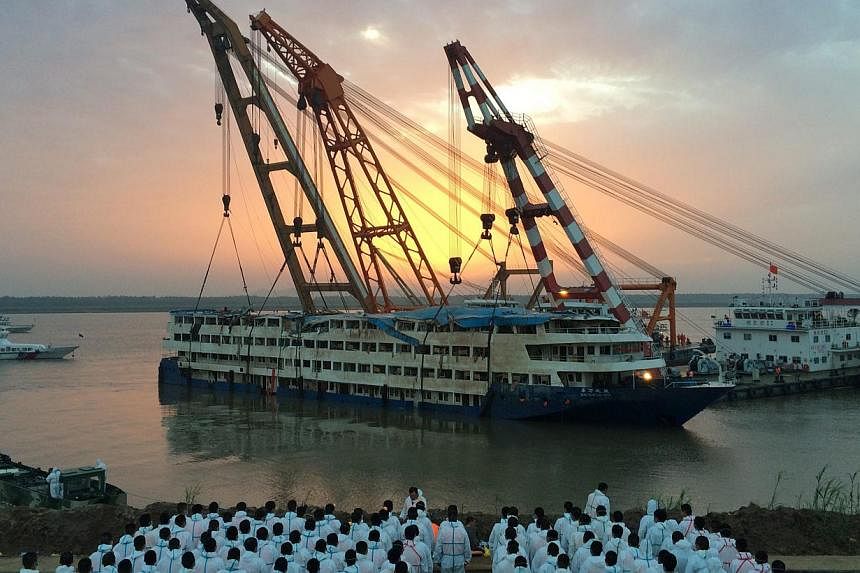 Paramilitary policemen wait to pick up bodies of victims after the cruise ship Dong Fang Zhi Xing, which capsized in the Yangtze River, was righted in Jianli county, southern China's Hubei province, June 5, 2015. -- PHOTO: EPA&nbsp;