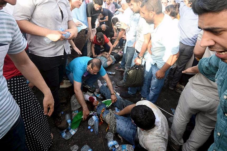 Injured people get first aid after an explosion during an election rally of the pro-Kurdish Peoples' Democratic Party (HDP) in Diyarbakir, Turkey, on June 5, 2015. Two people were killed and over 100 were injured when two explosions hit the rally, ju
