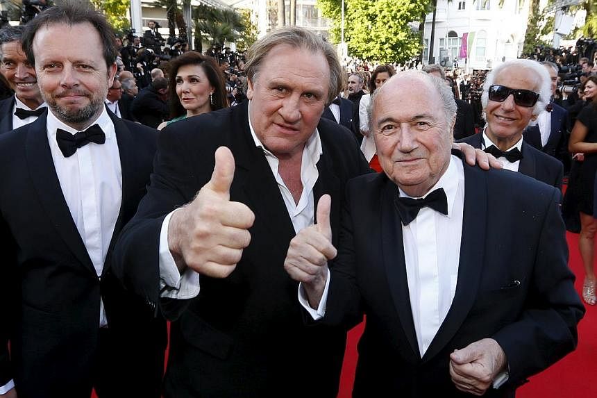 Actor Gerard Depardieu (centre), Fifa President Sepp Blatter (right) and director Frederic Auburtin posing on the red carpet for the screening of the film United Passions at the 67th Cannes Film Festival in Cannes, on May 18, 2014. -- PHOTO: REUTERS