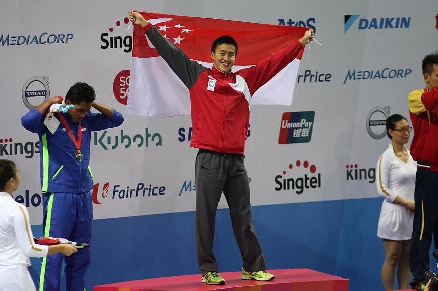 Singapore swimmer Quah Zheng Wen celebrating on the podium after his record-breaking SEA Games gold in the men's 100m backstroke on June 6, 2015. -- ST PHOTO: WANG HUI FEN&nbsp;