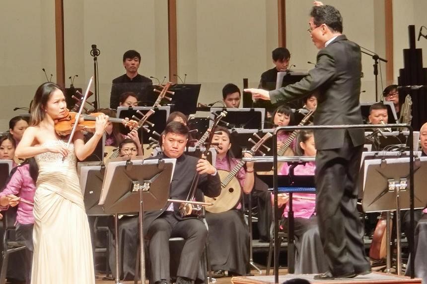 Violinist Kam Ning (left) performing with the Singapore Chinese Orchestra, conducted by Yeh Tsung. -- PHOTO: CHANG TOU LIANG