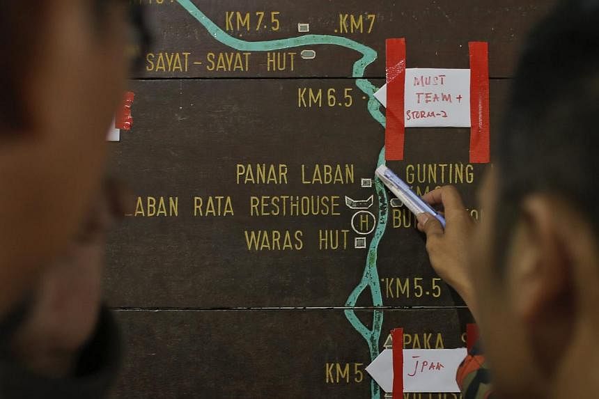 Malaysian rescue officials marking locations on an information board on the way to Mount Kinabalu during the rescue mission for more than 130 climbers stranded on one of South-east Asia's highest peaks after an earthquake rocked parts of Sabah, on Ju