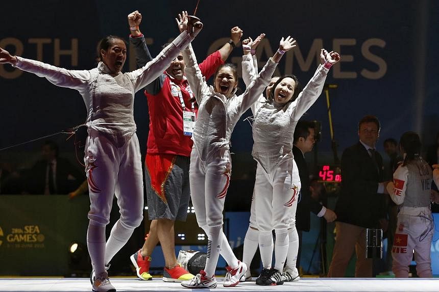 Singapore's women's foil team of (from left) Wang Wenying, Nicole Wong, Cheryl Wong and Liane Wong (hidden) celebrating after they beat Vietnam 45-26 in the SEA Games final on June 6, 2015. -- ST PHOTO: KEVIN LIM &nbsp;