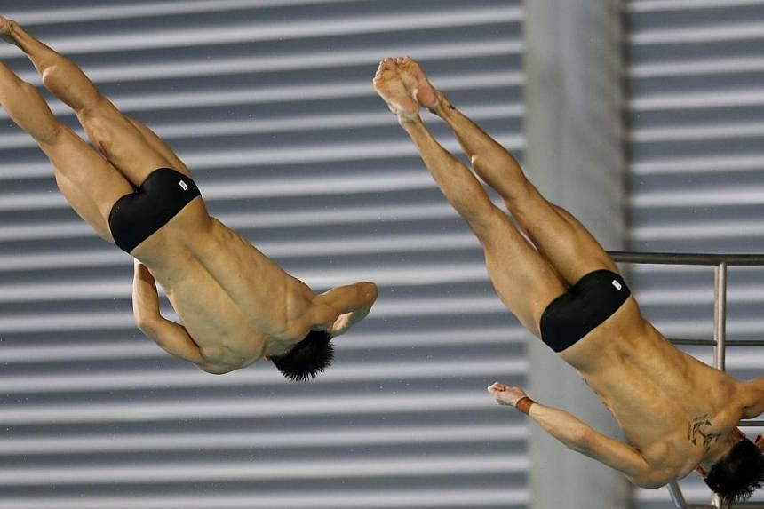 Malaysian divers Chew Yiwei (left) and Ooi Tze Liang (right) performing during the men's 10m synchronised platform final at the SEA Games in Singapore, on June 6, 2015. -- PHOTO: EPA