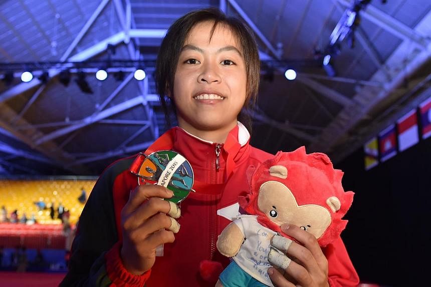 Judoka Ang Xuan Yi holding up the silver medal that she won in the women's 52-57kg event on June 6, 2015. -- ST PHOTO: CAROLINE CHIA&nbsp;