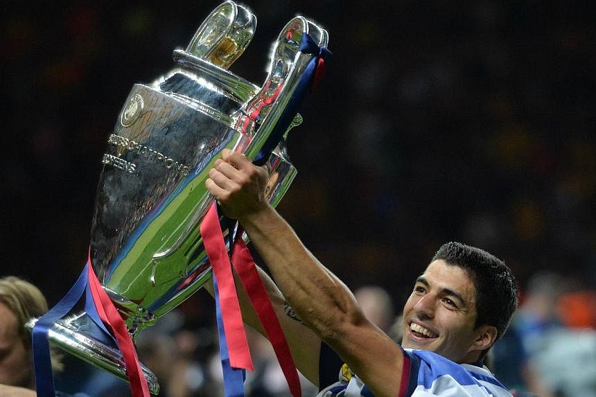 Barcelona's Uruguayan forward Luis Suarez celebrates with the trophy after the UEFA Champions League Final football match between Juventus and FC Barcelona at the Olympic Stadium in Berlin on June 6, 2015.&nbsp;
