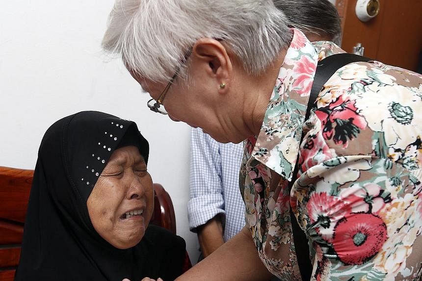 (Above) Madam Zawiah Ahid (with headscarf) meeting (from left) sixth sister Teo Kiat Chit, 74, third sister Teo Suak Huay, 85, and fifth sister Teo Suat Way for the first time since her adoption soon after birth. (Below) She could not stop her tears 