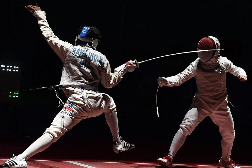 Kevin Jerrold Chan (right) of Singapore competes against Tauhid Ramadhan (left) of Indonesia during the 28th SEA Games held in Singapore on June 7, 2015. -- PHOTO: AFP