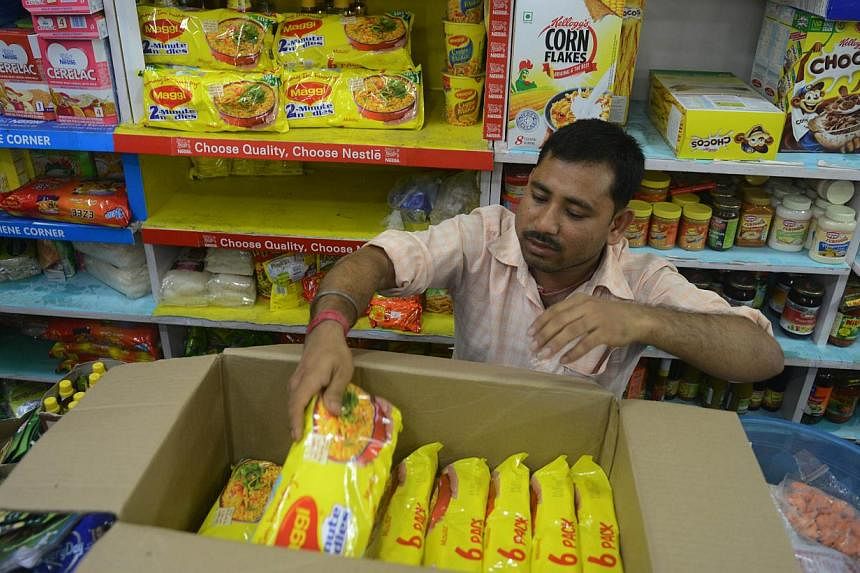 An Indian shopkeeper removes packets of Nestle Maggi instant noodles from the shelves in his shop in Siliguri on June 5, 2015. India's food safety regulator on June 5 banned the sale and production of Nestle's Maggi instant noodles over a health scar