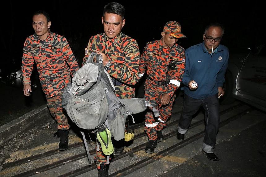 Members of a Malaysian Fire and Rescue Department team holding part of a body retreived from Mount Kinabalu on June 6, 2015. -- PHOTO: EPA