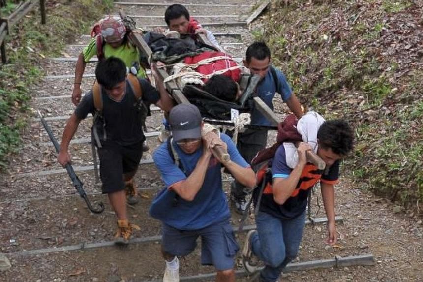 Sabahan mountain guides carrying an injured climber. -- PHOTO: THE STAR/ASIA NEWS NETWORK