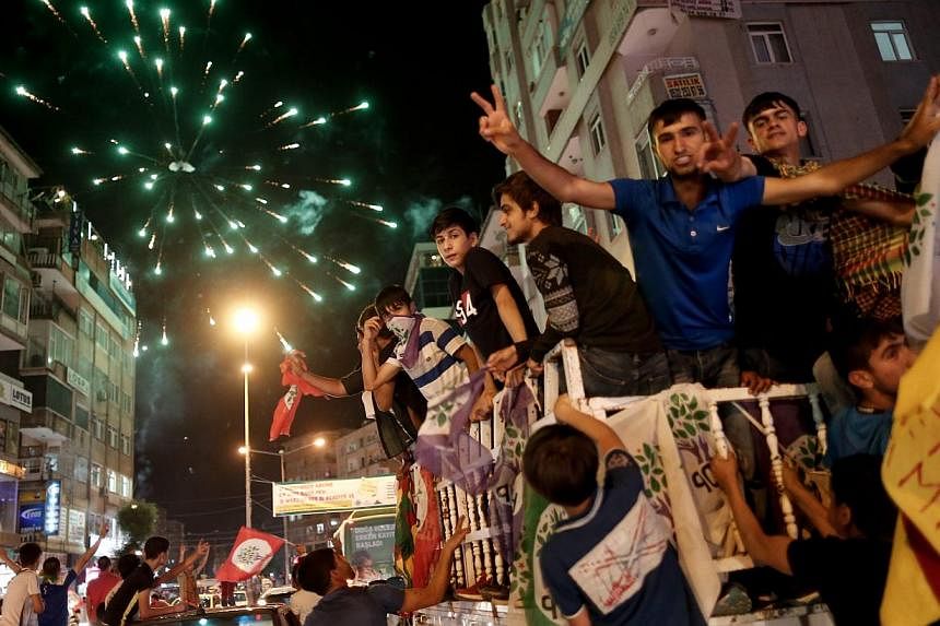 Supporters of the Peoples' Democratic Party (HDP) drive in a car convoys and launch firework in the streets as they celebrate the results of the Turkish parliamentary elections, in Diyarbakir, Turkey, on June 8, 2015. -- PHOTO: EPA