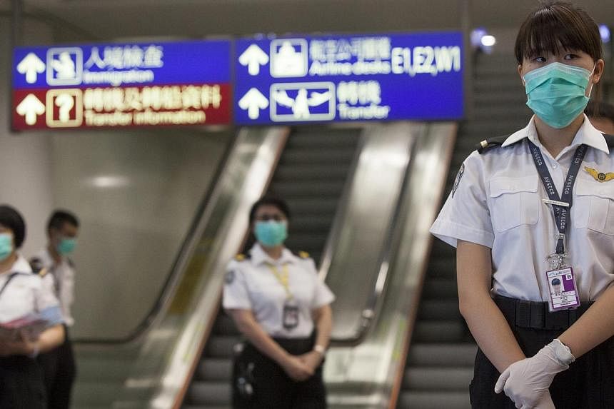 Health workers from Hong Kong's Department of Health are seen prior to checking passengers arriving for Middle East Respiratory Syndrome (MERS), at Hong Kong International Airport, Hong Kong, China, on June 5, 2015. -- PHOTO: EPA