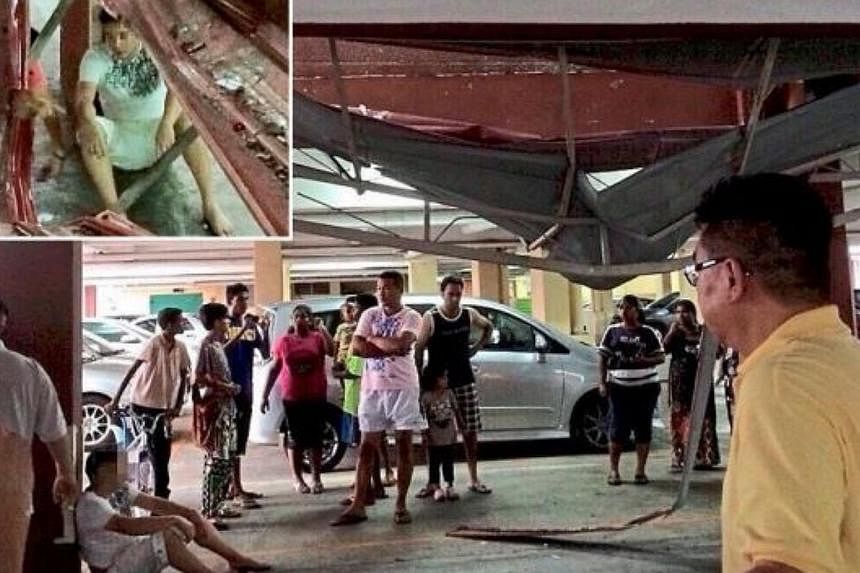 Residents checking on the dazed man (inset) after he fell from the eighth floor of a condominium. -- PHOTO: THE STAR/ ASIA NEWS NETWORK&nbsp;