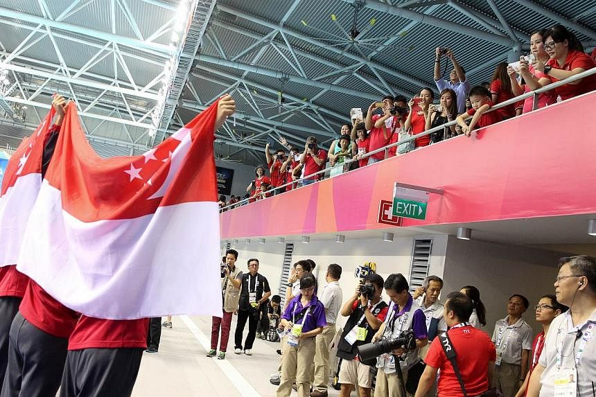 The women's 4x200m freestyle relay quartet of Quah Ting Wen, Amanda Lim, Rachel Tseng and Christie Chue acknowledging the crowd at the OCBC Aquatic Centre after their win.&nbsp;-- ST PHOTO:&nbsp;ONG WEE JIN