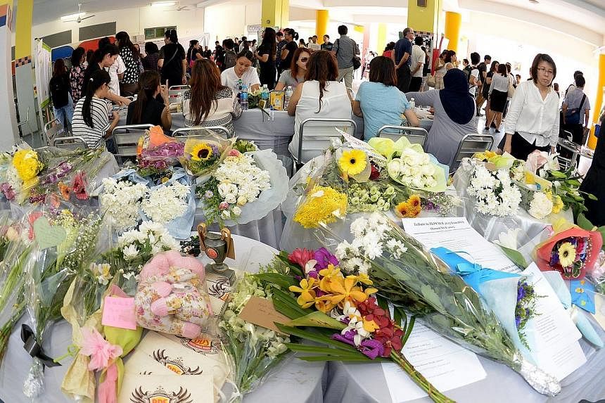 Bouquets of flowers that were left by hundreds of parents, pupils, alumni and staff at a condolence site in the school porch of Tanjong Katong Primary School on June 8, 2015. -- ST PHOTO: DESMOND WEE&nbsp;