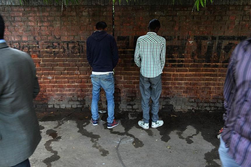 In this photograph taken on Nov 18, 2014, Indian men urinate on a wall at the roadside in New Delhi, the eve of World Toilet Day. A city council in western India is planning to pay residents to use public toilets in a desperate attempt to stop legion