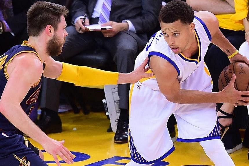 Golden State Warriors MVP Stephen Curry looks to pass under pressure from Matthew Dellavedova of the Cleveland Cavaliers during Game 2 in the best on 7 series 2015 NBA Finals on Sunday (June 7) in Oakland, California. -- PHOTO: AFP