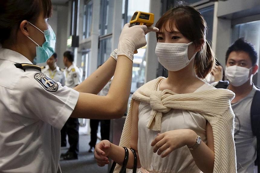 A passenger from Busan, South Korea, receiving a temperature check upon her arrival at Hong Kong Airport on June 5, 2015. -- PHOTO: REUTERS