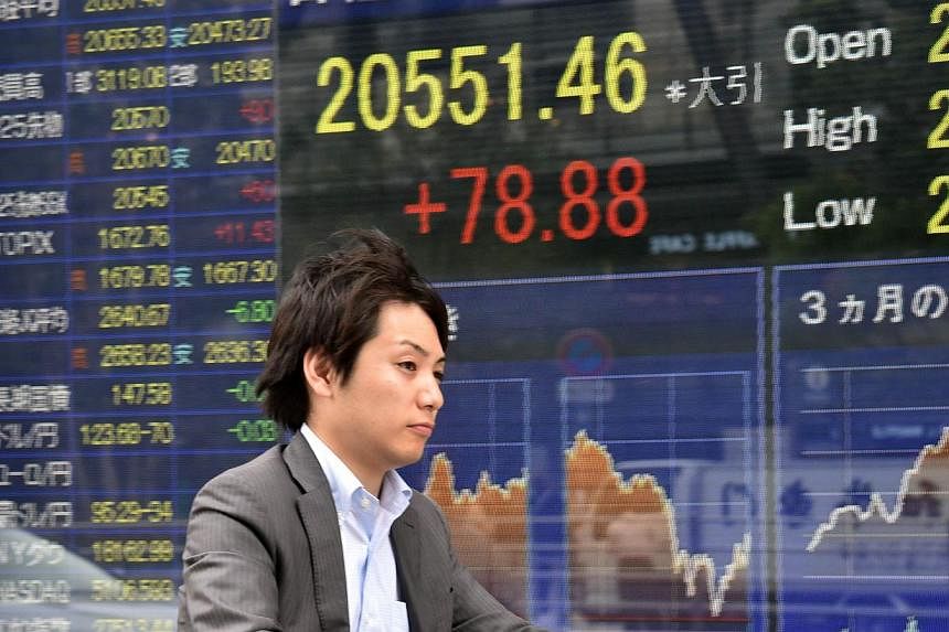 Asian stocks gained early on Thursday after seeing Wall Street shares halt their selloff, while the New Zealand dollar tumbled to a five-year low after the Reserve Bank there cut its overnight cash rate. -- PHOTO: AFP