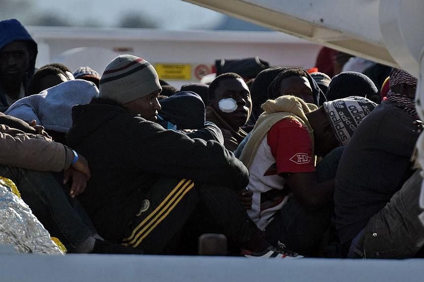Shipwrecked migrants sitting on the deck of a rescue vessel as they arrived in the Italian port of Augusta in Sicily in April. A market in which states can buy and sell all or part of their protection quota obligations should be created, suggests the