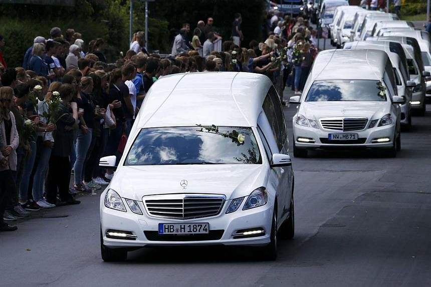Hearses carrying the remains of victims of the Germanwings plane disaster drive past the Joseph-Koenig-Gymnasium high school, where 16 of the victims went to school, in Haltern am See, Germany, on June 10, 2015. -- PHOTO: REUTERS