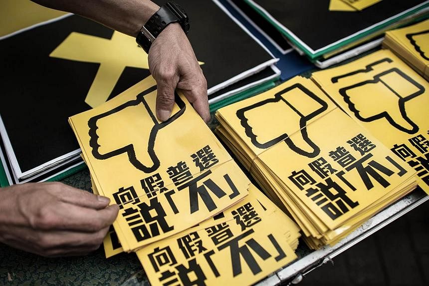 In this picture taken on April 26, 2015 in Hong Kong, a pan-democrat arranges leaflets against the government's controversial leadership election roadmap which sticks to a ruling from Beijing that all candidates should be vetted before a public vote 