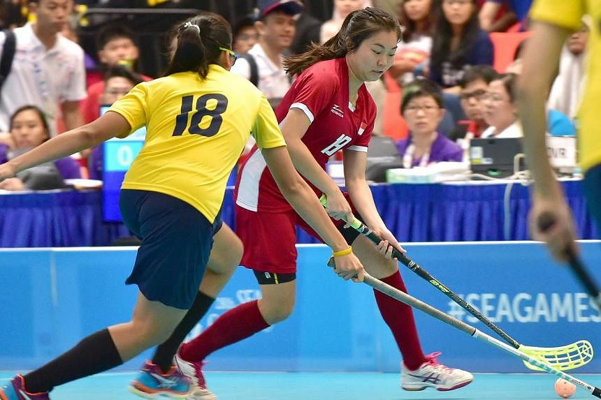 Singapore and Malaysia women's floorball teams in action at ITE College Central on June 11, 2015. Singapore's floorball teams are off to a flying start on the opening day of the SEA Games competition on Thursday, with both men and women chalking up b
