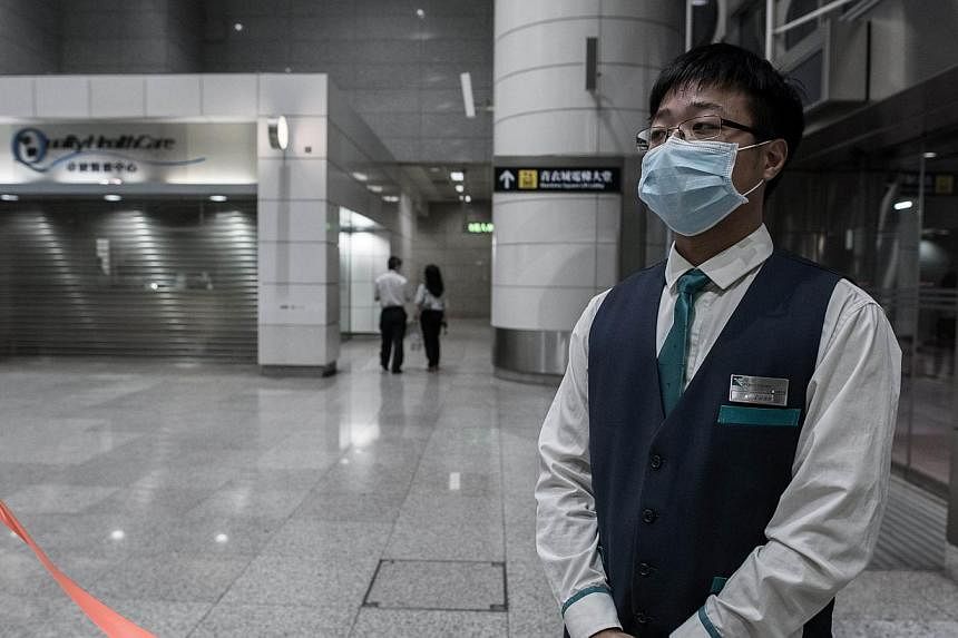 An MTR employee stands by a restricted area next to a closed clinic at the Tsing Yi MTR station in Hong Kong on June 10, 2015. -- PHOTO: AFP