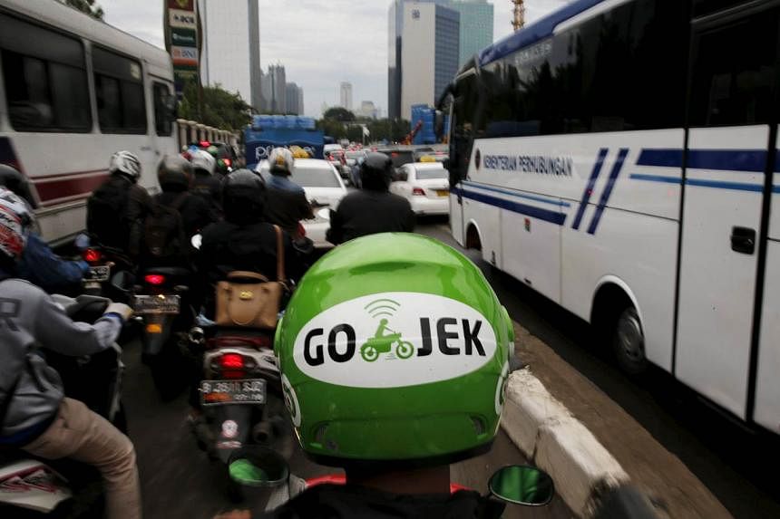 A GO-JEK driver rides his motorcycle through a business district street in Jakarta on June 9, 2015. Jakarta's traffic jams are a constant vexation for the city's 10 million residents but the Indonesian capital's glaring inefficiencies have also creat
