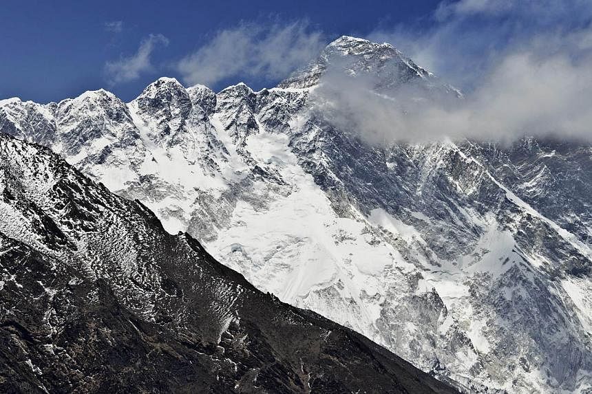 A view of Mount Everest (background) towering over the Nupse-Lohtse massif (foreground) from the village of Tembuche in the Khumbu region of north-eastern Nepal on April 20, 2015. -- PHOTO: AFP
