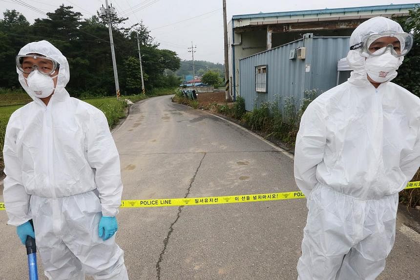 Health workers in protective suits standing by a quarantined village in Boseong, at the tip of the South Korean peninsula, on June 11, 2015. -- PHOTO: AFP