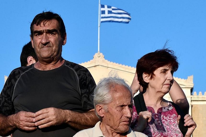 Protesters stand in front of the Greek parliament in central Athens during a rally against the EU-IMF loan deal on June 11, 2015. Greece's creditors piled pressure on cash-strapped Athens on Thursday as the IMF pulled its team out of talks and the EU
