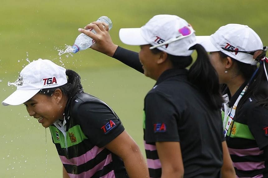 Thailand's Suthavee Chanachai is drenched in water by her teammates after winning the gold medal from the 28th SEA Games golf women's individual at Sentosa Golf course on June 12, 2015.&nbsp;-- ST PHOTO: KEVIN LIM