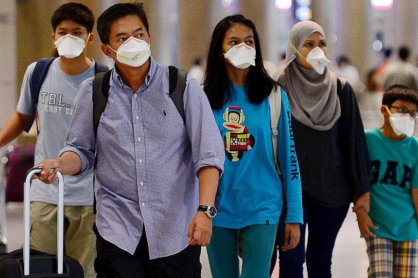 Tourists wearing masks to prevent themselves from contracting Middle East Respiratory Syndrome (Mers) arrive at the Incheon International Airport in South Korea on June 7, 2015. -- PHOTO: REUTERS