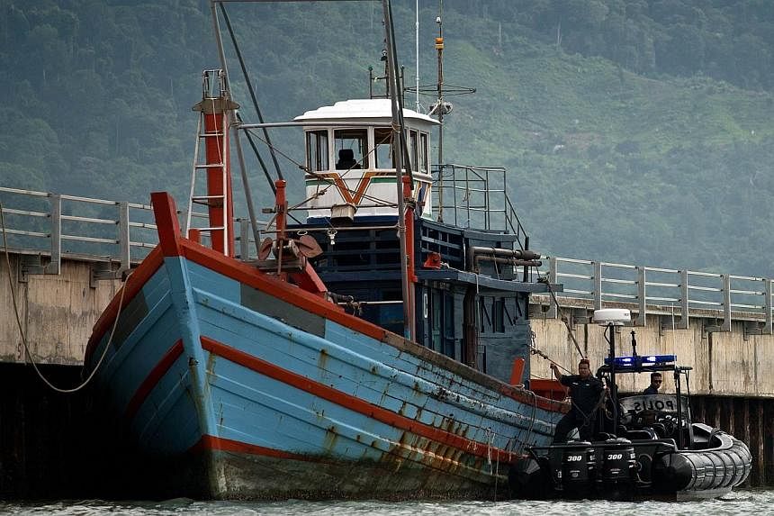 Malaysian maritime police inspecting a boat which carried illegal migrants in Langkawi on May 12, 2015. -- PHOTO: AFP