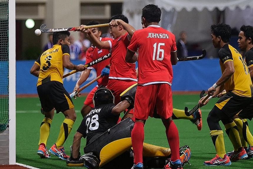 Singapore scoring a goal against Malaysia in the men's hockey final at the Sengkang Hockey Stadium on June 13, 2015. -- ST PHOTO: NEO XIAOBIN