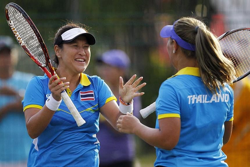 Thailand's Tamarine Tanasugarn and Noppawan Lertcheewakarn celebrate as they win the gold medal in the Tennis Women's Team Final. -- PHOTO: SINGAPORE SEA GAMES ORGANISING COMMITTEE/ACTION IMAGES VIA REUTERS
