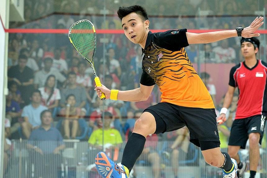 Malaysia's Muhd A. Bahtiar goes for the ball as he plays against Singapore's Samuel Kang.&nbsp;Singapore had to settle for the SEA Games squash men's team silver after losing the final 0-2 to Malaysia on Saturday, June 13, 2015. -- ST PHOTO:&nbsp;KUA