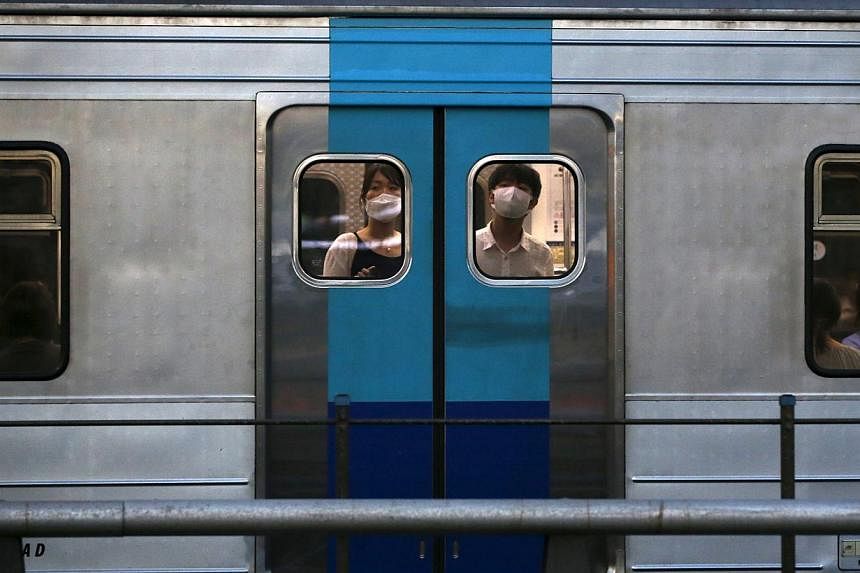 Passengers wearing masks to prevent contracting Middle East Respiratory Syndrome (Mers) look out from a subway train in Seoul, South Korea, on June 12, 2015. -- PHOTO: REUTERS&nbsp;