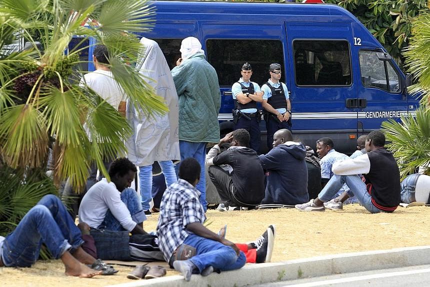Migrants waiting face French gendarmes at the border between Italy and France in the city of Ventimiglia, Italy, on June 13, 2015. -- PHOTO: AFP