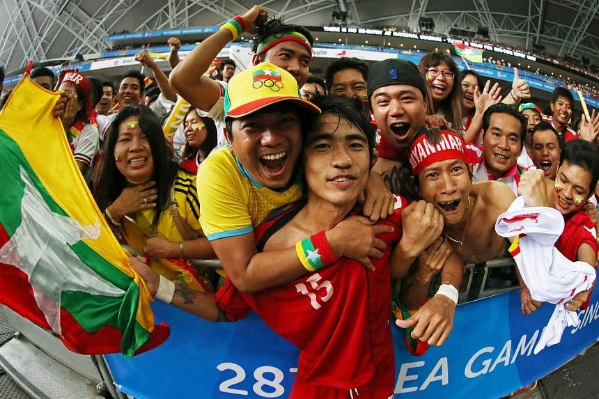 Myanmar footballer Zaw Hein Thiha (centre) celebrating with fans after his country's shock 2-1 win over Vietnam in the SEA Games men's football semi-finals at the National Stadium on June 13, 2015. -- PHOTO: SINGAPORE SEA GAMES ORGANISING COMMITTEE/A