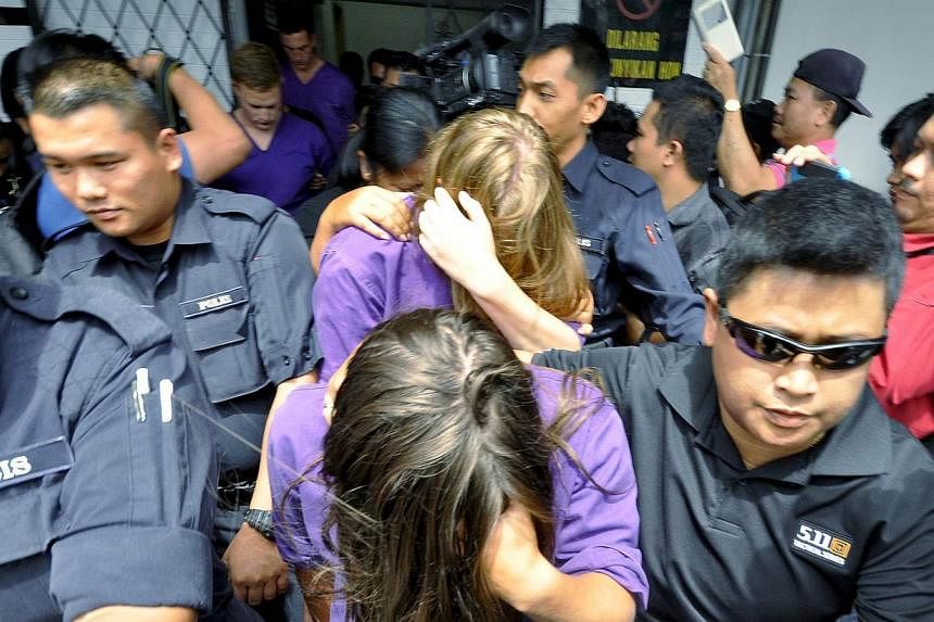 British national Eleanor Hawkins (front), along with three other tourists from Canada and the Netherlands, are escorted by police as they leave a court hearing in Kota Kinabalu, in Malaysia's eastern state of Sabah on June 10, 2015. -- PHOTO: REUTERS