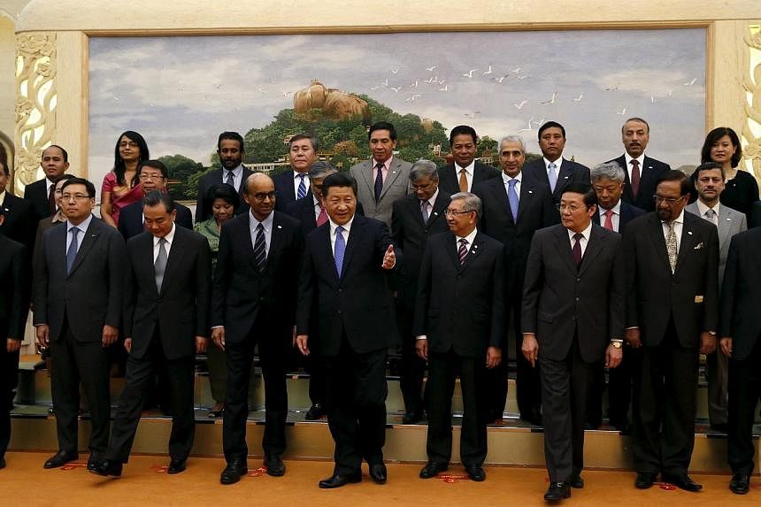 China's President Xi Jinping (front, centre) guiding guests at the Asian Infrastructure Investment Bank launch ceremony at the Great Hall of the People in Beijing on Oct 24, 2014. -- PHOTO: REUTERS&nbsp;