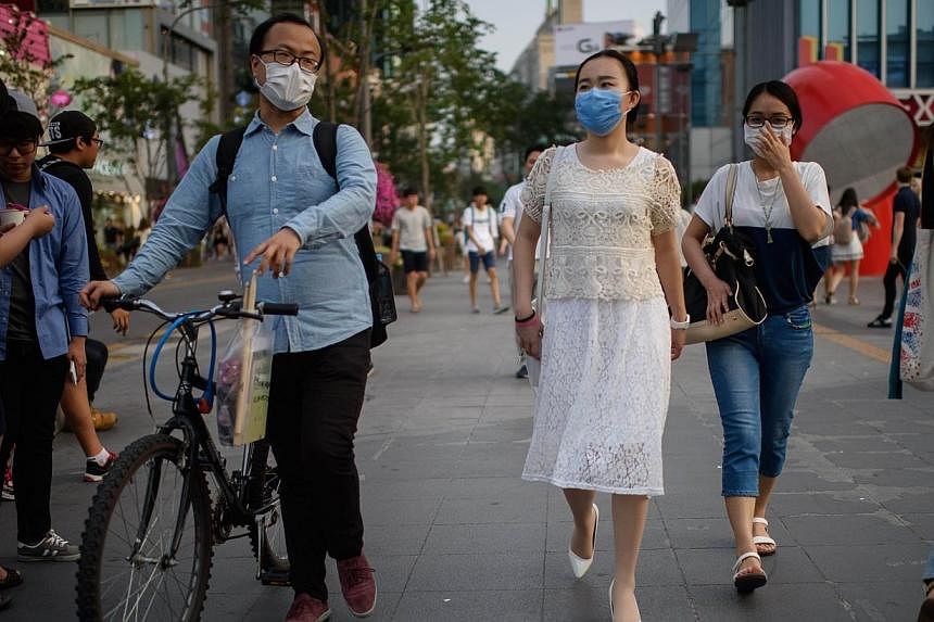 People wearing face masks in Seoul on June 14, 2015. -- PHOTO: AFP&nbsp;